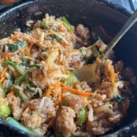 Dolsot bibimbap after adding sauce and stirring. It goes crispy in the smoking hot cast iron bowl    at Cahchi Korean BBQ Restaurant in New Malden