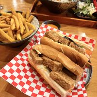 Vegan Banh Mi sandwich cut in half, revealing layers of crispy tofu, eggplant, pickled carrots and daikon, cucumber, coriander, and vegan mayo inside a crusty baguette.  at Madame Pho - Exchequer St  in Dublin