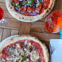 Red hot chili pizza and Parmigiana vegana pizza with spritz drinks. at Strazzaria in Venice