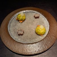 creamy cashew-apple bite on a crunchy bed of almonds and a gummy bear-like bite (flower) of made of spicy raspberry and red bell pepper   at Pramerl & the Wolf in Vienna