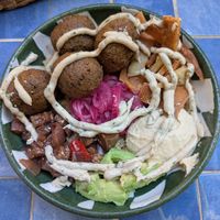 DYI vegan bowl w/ quinoa, falafel, pickled onions, sauteed veg, avocado, hummus, pita chips, and tahini dressing 🤩 at Good Friends in El Tunco