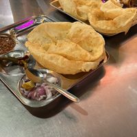 Chole Bhature (plain - without paneer). They were much poofier before puncturing!  at Amritsari Kulche Wale - अमृतसरी कुलचे वाले in Jaipur