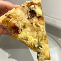 Slice of delivered Green BBQ vegan pizza with bbq sauce, plant based "meat", portobello mushrooms, fresh onion and grated vegan cheese at Papa John's  in Oviedo