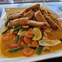 Nr. 172 Asiatische Nudeln mit Gemüse und 8 Mini-Frühlingsrollen, serviert mit einer Mango-Kokos-Sauce at Green Rice in Schwerin