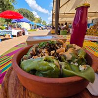 Steamed dumplings with cabbage and tofu topped with peanut sauce and chilies. Cold drink. at Kiota Food in Nairobi