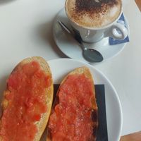 Bread with oil and tomato and soy milk cappuccino at Isolina  in Malaga