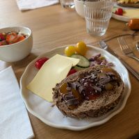 Breakfast. Granola, fruit and yogurt in the bowl. Cheese, meat pastes etc, and bread with preserves topped with chocolate at HOTEL BENT Restaurant in Oisterwijk