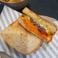 Veggie toastie: seasoned butternut squash, red onion, peppers, vegan feta cheese & black olives with red pepper tapenade & a herby vegan dressing on sourdough bread. With chips at Marks & Spencer in Wilmslow