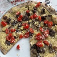 Pizza vegan con hummus, melanzane, pomodorini, semi di sesamo e scorza di limone  at Berbère - San Lorenzo in Rome