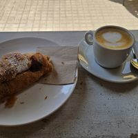 Vegan croissant with strawberry jam and coffee with oat milk at Crois Spazio Bar in Barcelona