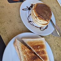 Vegan pancakes w/ maple syrup & chocolate with a sausage & onion toasted sandwich. at Churchill's Kandy's in Mallorca