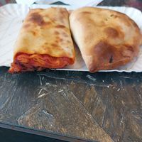 Scaccia with tomato sauce and onions and calzone with spinach,black olive and dry tomato at Squitty Di Cintoli Battista Maria in Ragusa