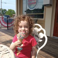 Vanilla hard serve ice cream with rainbow sprinkles on a cone on our site patio. at Lock 24 Ice Cream  in Baldwinsville