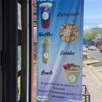 Their banner outside with a partial menu.  at Smoothie House  in Atenas