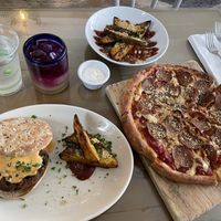 Malibu melt (black bean burger) with potato wedges, extra potato wedges, and a pepperoni pizza. All vegan! Butterfly pea flower tea drink (virgin cocktail) was also delicious  at Seedz Cafe in St Louis