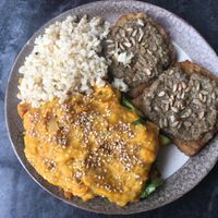 Plate with a mix of two dishes of the day : on the left, tempeh with grilled vegetables, topped with a leek and carrot purée ; on the right, seitan steak with mushroom sauce at Alfarroba in Lisbon