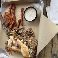 Philly cheese steak with sweet potato fries. My husband had already ate some of it before the picture was taken. He loved it!   at Midway Bar in Midvale