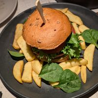 Burger with Peas Out patty, baba ghanoush, pickled onion, tomato, green salad  with sheese sauce and fries at Vegan Restoran V in Tallinn