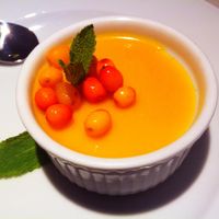 Cashew creme dessert topped with buckthorn jelly. Raw and gluten free. at Vegan Restoran V in Tallinn