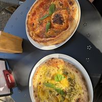 Pizza Margherita (oben) und Pizza Pesto i Pomodoro gialli (unten) auf einem Aussentisch  at volare in Leipzig