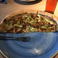 Vegan pizza with artichoke, charred broccolini, summer squash, pickled jalapeño, basil cashew drizzle, garlic oil, and sunflower seeds  at Marzano in Nelson