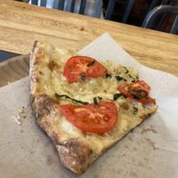 Slice of vegan cashew cheese pizza at Green Oven Pizza in New York City