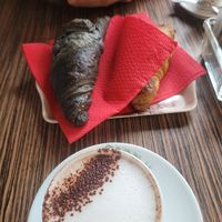 Cappuccino + charcoal croissant and berries croissant at Veganda in Padua