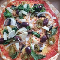 Vegan cheese with onion, roasted garlic, portobello mushroom, pineapple, Jalapenos, kalamata olives, spinach, and basil at 900 Degrees in England