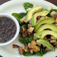Side of black beans(they don't use meat broth or lard!), raw spinach, home fries, and avocado. at Food Bash in Winchester