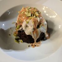 Warm chocolate cake, served with ice cream, hazelnut butter, and pistachio at Anastasia in Tel Aviv