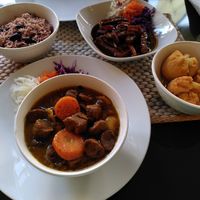Clockwise: peppered strips, fried dumplings, curry chunks, rice and beans at Fi Real in Bristol