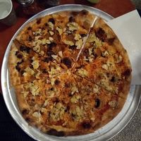 Large pizza with variety of toppings at Hatool HaYarok - The Green Cat in Tel Aviv