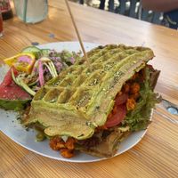 Spinach Waffle sandwich - soy gyros, tomato, avocado cream, and hummus. Includes small salad. at Moehren Milieu Eco Cafe in Mainz