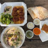 Wonderful dish including hummus, rice, pita, Baba Ghanoush, salad, great spicy dips. at Jerusalem Restaurant in Peoria