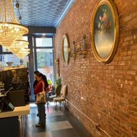 Inside Delice de Bernay. There is a table for inside eating, dedicated to the bakery, plus a table in front at Délice de Bernay in New York City