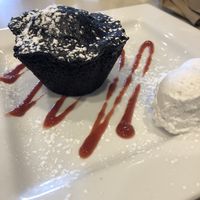 Chocolate vegan cake with raspberry coulis and whipped coconut cream. at Bravo in Jackson