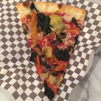 Yummy vegan pizza slice topped with veggies at Plaza Hotel - Pop Up Pizza in Las Vegas