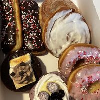 Two chocolate frosted long johns, cinnamon sugar topped cinnamon roll, vanilla frosting topped cinnamon roll, s’mores, mixed berry, two strawberry frosting topped donuts  at Uffda Donuts in Blaine
