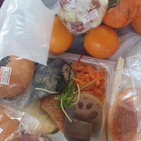Box with side dishes, rice balls, an Pan and organic kaki at VEGE & DELI - らでぃっしゅ in Takamatsu