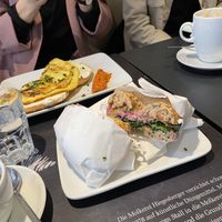 vegan bagel with red-beet-hummus, pickles, onions, ruccola and sweet mustard; in the background vegetarian bagel omelette   at Blueorange Coffee and Bagel - Margaretenstrasse in Vienna
