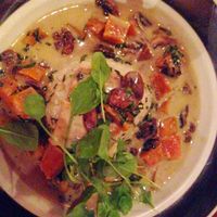 Vegan Green Curry: Pan-seared tofu, pumpkin, and mushrooms, smothered with a coconut milk thai curry sauce, served on sushi Rice and topped with fresh mixed greens at Harmony Hotel Restaurant in Nosara