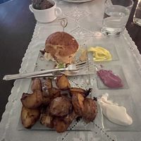 Vegan lentil-based burger, and potato wedges with 3 different types of dipps.   at Moon in Siracusa