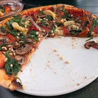 Vegan pizza with spinach, mushrooms, tomatoes and artichokes at La Piazza Verde in Zuid-holland