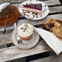 Top left: carrot cake, top right: raspberry cheesecake, bottom right: pizza slice, bottom left: lemon curd cupcake  at Café Schwestis in Sachsen