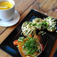 Veganised Polish dish with stuffed potatoes, served with pickles, and lemon tea at Vege Miasto in Warsaw