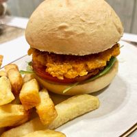 "Tortuga" vegan burger with French fries: pumpkin, carrot, garlic and ginger patty, battered in chickpea flour, arugula, tomato, onion and apple ketchup at El Bucanero in Oviedo
