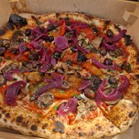 Neapolitan pizza with mushrooms, bell peppers, sweet onion, fresh olives and tomatoes and vegan cheese. Drizzled with garlic oil and sprinkled with parsley at Semo. Italian Street Kitchen  in Copenhagen