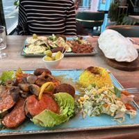 Vegan grill with rice & vegan mezze with giant olives & freshly baked flatbread in background   at Olive & Thyme in Manchester