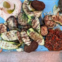Vegan mezze with houmous, grilled courgette, aubergine, mushrooms, giant olives, ezmal dip, salad  & freshly baked flatbread   at Olive & Thyme in Manchester