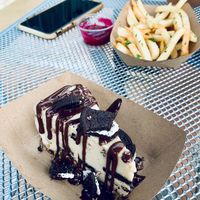Background, seasoned French fries with a beet dip. In the foreground, a cookies and cream cheesecake so sweet and decadent it will make your heart break.. in a good way, of course! at Avo in Nashville